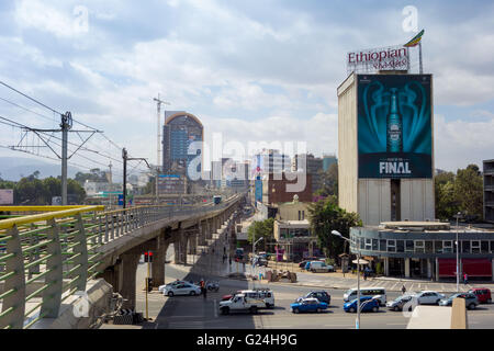A busy intersection in Addis Ababa, Ethiopia. An elevated light rail track passes over top of the streets below Stock Photo