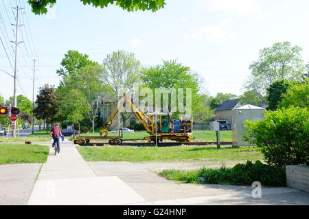 A railway vehicle crossing a road in London, Ontario in Canada. Stock Photo