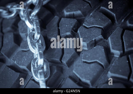 Close up shot of some chains wrapped around a car's tire. Stock Photo