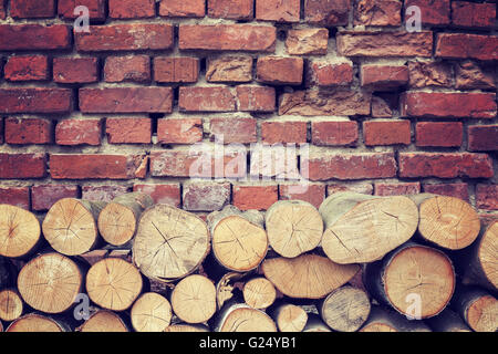 Vintage toned tree stumps and old brick wall background. Stock Photo