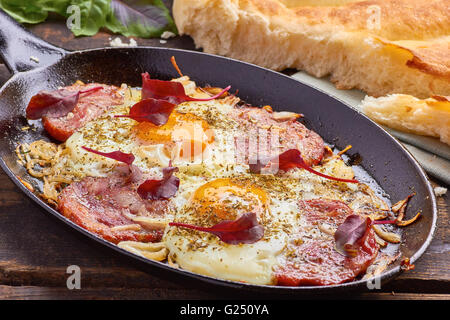 Pan of fried eggs with onion, ham and chard Stock Photo