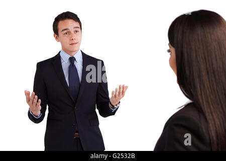 A young Caucasian business man is looking at a business woman. His eyebrow is raised and looking doubtful. Stock Photo