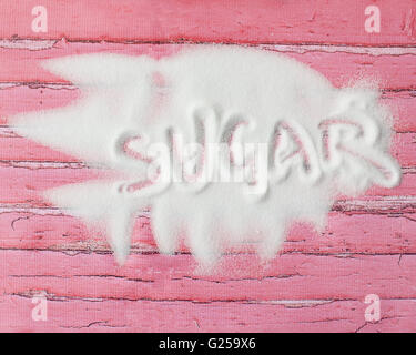 Word sugar written in sugar on pink wooden table Stock Photo