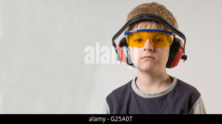 Portrait of a boy wearing safety glasses and ear defenders Stock Photo