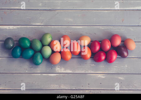 Multi-colored easter eggs on wooden table Stock Photo