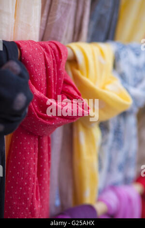 Close-up of multi coloured scarves hanging on rail Stock Photo