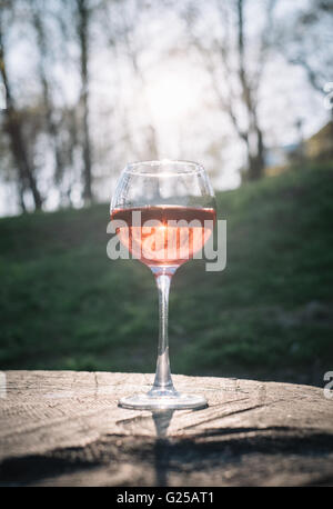 Glass of rose wine on wooden table Stock Photo