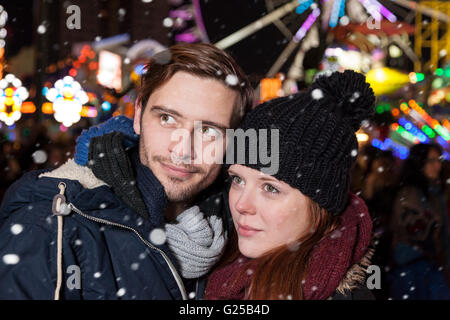 Couple on christmas fair looking at something Stock Photo