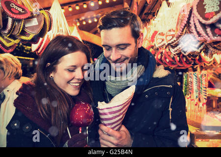 Couple on christmas market eating sweets (vintage look) Stock Photo