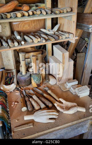 Carved wooden hands and chisels plus woodworking tools in a wood sculptures workshop. UK Stock Photo