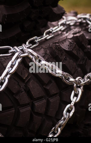 Close up shot of some chains wrapped around a car's tire. Stock Photo