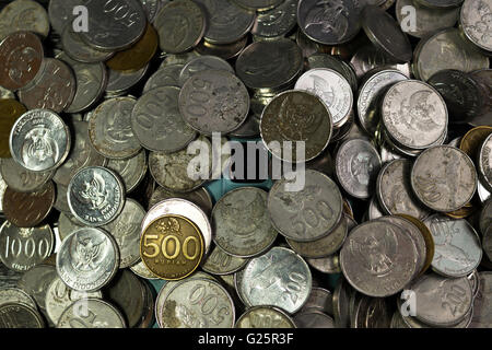 Stack of coin of rupiah and smartphone camera. Show the relationship.  Indicate how business or money and smartphone camera is i Stock Photo