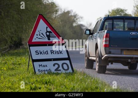Road re-surfacing and associated skid risk slowing traffic on a British rural road. Stock Photo