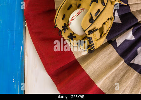Close up of old worn baseball equipment on a wooden background. Stock Photo