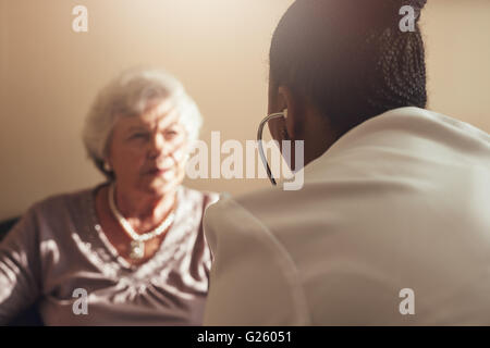 Female doctor with stethoscope examining senior woman patient Stock Photo
