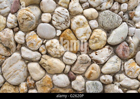 Pebble stones in a bright stone wall Stock Photo