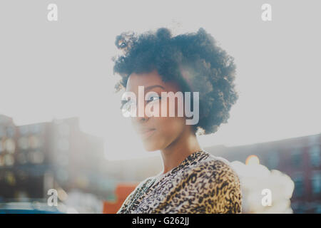 Young woman with afro smiling in urban setting Stock Photo