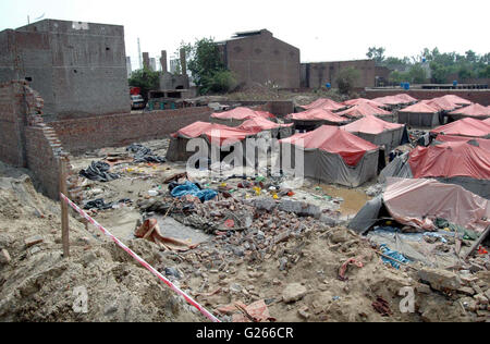 View of demolished wall of Orange Line train project under- construction godown after wall collapsed incident near Quaid-e-Azam Terminal at GT road in Lahore on Tuesday, May 24, 2016. At least seven labours working on the Orange Line train project lost their lives when the wall of an under-construction godown collapsed on them as they were sleeping in their tents. Stock Photo