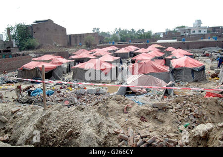 View of demolished wall of Orange Line train project under- construction godown after wall collapsed incident near Quaid-e-Azam Terminal at GT road in Lahore on Tuesday, May 24, 2016. At least seven labours working on the Orange Line train project lost their lives when the wall of an under-construction godown collapsed on them as they were sleeping in their tents. Stock Photo