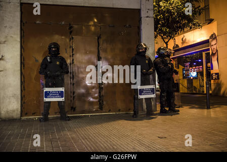 Barcelona, Catalonia, Spain. 25th May, 2016. Catalan riot police stand guard in front of a welded former bank office as pro-squatter protesters gather at a nearby place to demonstrate for the third night in row against it's recent eviction after it has been used by squatters for the past years as an autonomous social-center Credit:  Matthias Oesterle/ZUMA Wire/Alamy Live News Stock Photo