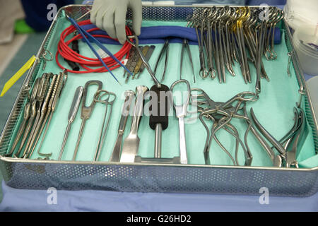 Instruments in hospital theatre with a hand reaching in Stock Photo