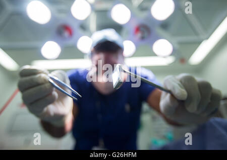 Patient's eye view of surgeon in a theatre bending over during an operation Stock Photo