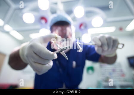 Patient's eye view of surgeon in a theatre bending over during an operation Stock Photo