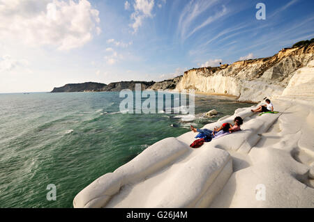 People relaxing on the beautiful white marl cliff of the Scala dei Turchi, Realmonte, Sicily, Italy Stock Photo