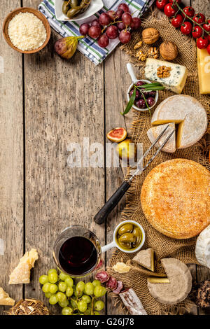 Various kind of traditional cheese and delicacy suitable for wine, placed on wood, shot from high angle view. Stock Photo