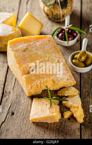 Parmesan cheese on cutting board placed on wood, low depth of focus Stock Photo