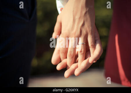 Wedding couple holding hands on sunset background Stock Photo