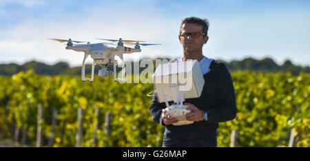 Man flying drone in wineyard, Champagne, France Stock Photo