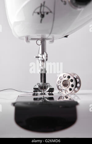 Front detail sewing machine needle and thread spool. Vertical composition. Front view close up Stock Photo