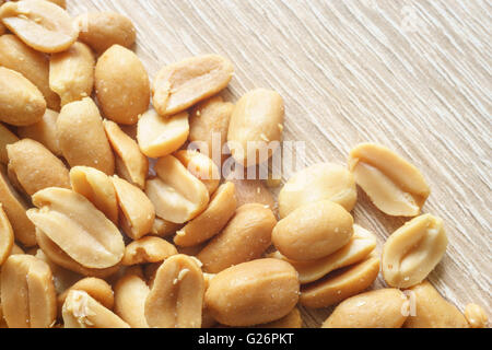 Closeup on roasted salted peanuts, wooden background, diagonal composition Stock Photo