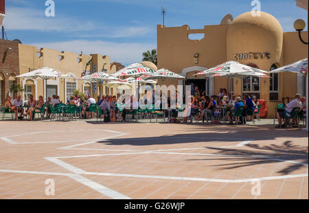 Tourist crowd at a sunday afternoon on sunny terrace at bar, Port of Fuengirola, Andalusia, Costa del Sol, Spain. Stock Photo