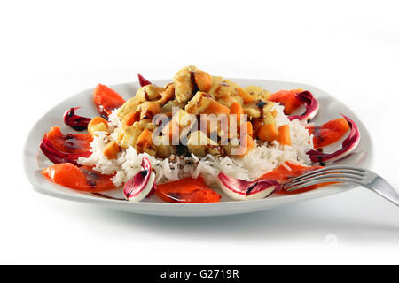 Rice plate with diced chicken carrots and potatoes surrounded from radicchio and peppers garnished with balsamic vinegar Stock Photo