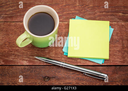 blank sticky notes, pen and espresso coffee on a rust barn wood table Stock Photo