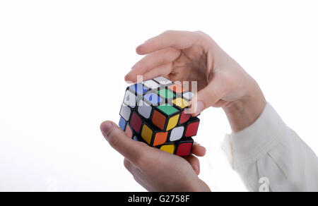 Child holding a Rubik's cube in hand on a white background Stock Photo