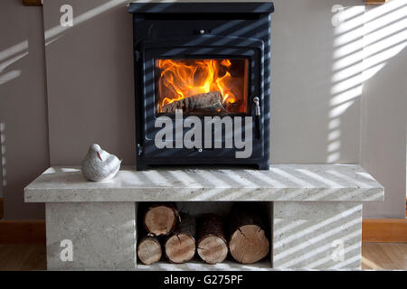 Log fire with shadows from early morning sun. Stock Photo