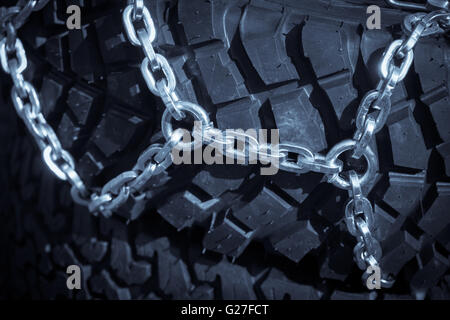 Close up shot of some chains wrapped around a car's tire. Stock Photo