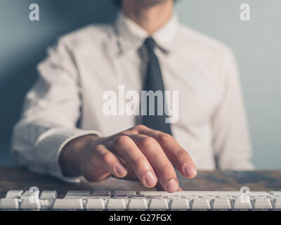 A young businessman is typing on a keyboard Stock Photo