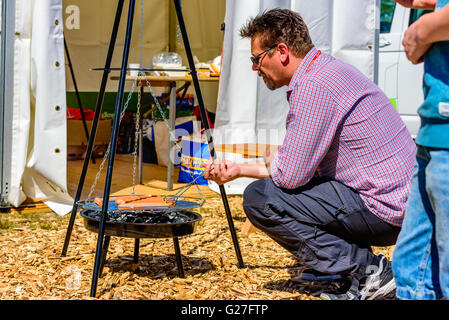 Emmaboda, Sweden - May 13, 2016: Forest and tractor (Skog och traktor) fair. Salesperson grilling some hot dogs for the visitors Stock Photo
