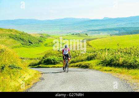 Cyclist on lane climbing to The Oa on the island of Islay Scotland Stock Photo