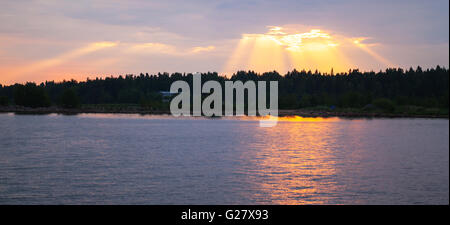 Sunset over Baltic Sea coast, sunbeams goes trough stormy clouds. Gulf of Finland Stock Photo