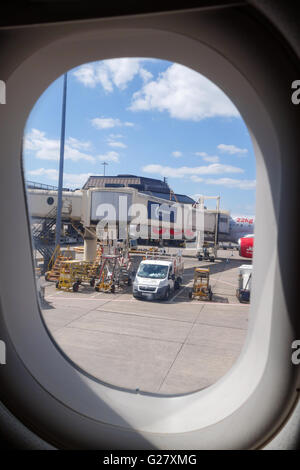 Looking through an aircraft window at a jet bridge or passenger boarding bridge at Manchester Airport England UK Stock Photo