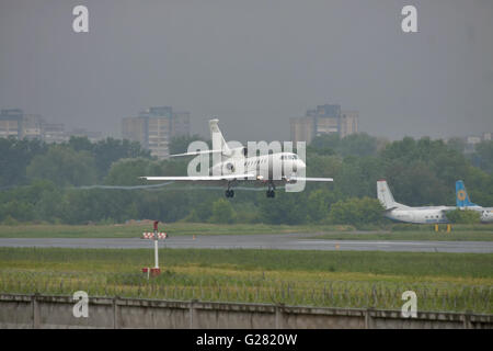 Kiev, UKraine - June 5, 2012: Dassault Falcon 50EX business jet is landing in bad weather conditions under heavy rain Stock Photo
