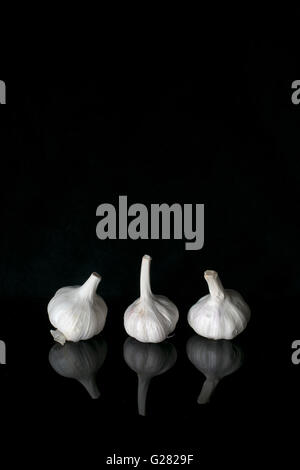 three garlic bulbs in a row Stock Photo