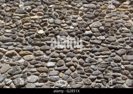 Ancient wall of gray rounded natural stones Stock Photo