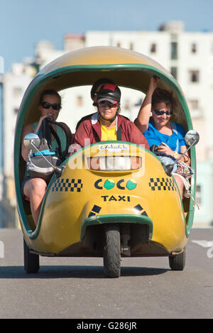 A coco taxi with passengers driving along the Malecón in Havana La Habana, Cuba. Stock Photo