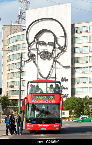 A tourist Havana La Habana hop on hop off bus on Revolution Square with the image of Camilo Cienfuegos in the background. Stock Photo